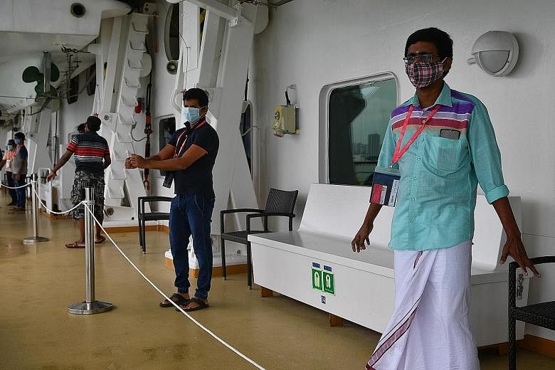 Mr Rajagopal Sathiyavasan (in green shirt) and his fellow migrant workers doing some simple exercises during their allocated free time on the deck of SuperStar Gemini last Saturday. ST PHOTO: CHONG JUN LIANG