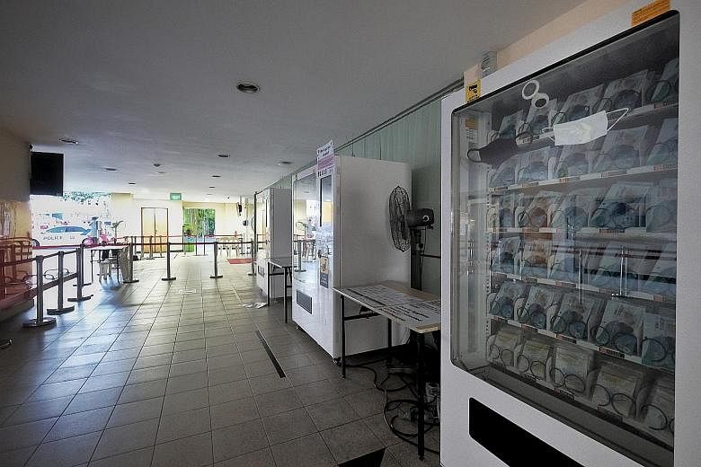 Mask vending machines and queue barricades set up at Toa Payoh Central Community Club yesterday, in preparation for the mask collection exercise that starts today. Singapore residents with a valid identification document can collect one reusable mask