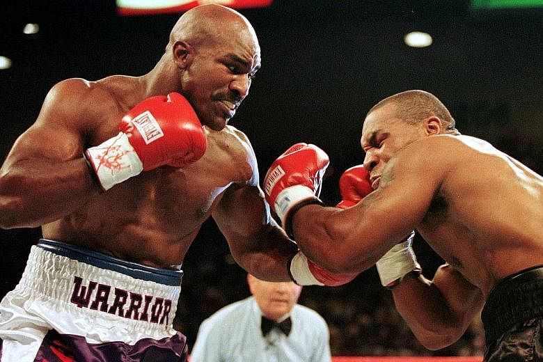 Evander Holyfield connecting with a left in his heavyweight bout against Mike Tyson in 1997, which was notoriously known as 'The Bite Fight' after the latter was disqualified for biting off a chunk of his opponent's ear.