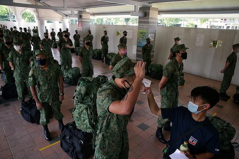 Singapore Armed Forces recruits observing social distancing while waiting to have their temperature taken at Pasir Ris Bus Interchange yesterday, when basic military training (BMT) resumed. Of the 6,300 who will resume BMT, about 1,500 recruits repor