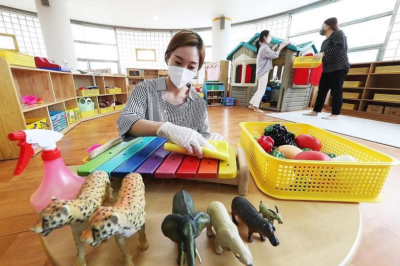 Teachers disinfecting toys at Hanil Kindergarten in Suwon, South Korea, yesterday. The country's second phase of school reopening begins today, with 2.37 million students, including kindergarteners and elementary school pupils, set to return. Many pa