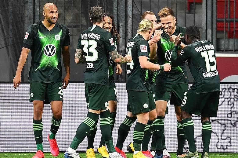 Marin Pongracic (second from right) is surrounded by teammates after putting Wolfsburg 4-0 up with his second goal against Leverkusen.