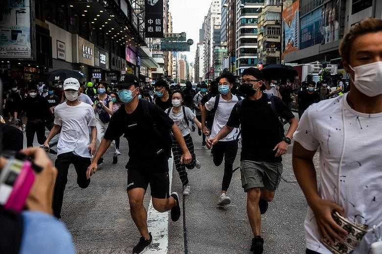 Protesters running as riot police arrived to clear a road they were occupying in Hong Kong's Mong Kok district yesterday. Police said at least 300 people were arrested yesterday for unauthorised assembly and possession of offensive weapons including 