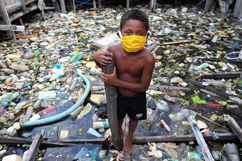 A boy from the Educandos riverside community in Manaus, the Amazon, on Tuesday. As Brazil's daily death rate became the world's highest on Monday, a University of Washington study warned that the country's total death toll could climb five-fold to 12
