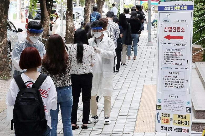 People waiting in line to be tested for coronavirus at an outdoor clinic in Bucheon, South Korea, yesterday. The new cases are mostly centred in the Seoul metropolitan area where half the South Korean population lives.