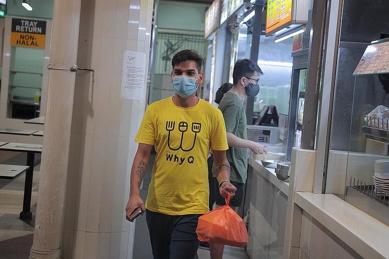 A WhyQ employee with food collected from a stall in Bukit Panjang for delivery yesterday. The new Marketplace@WhyQ, unlike other delivery platforms, will charge its operators no commission or start-up fees.