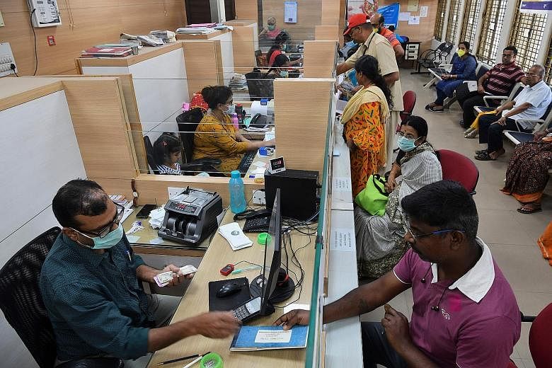 Bank clerks wearing masks amid concerns over the spread of coronavirus in a Bangalore bank earlier this year. With India's lockdown on March 24, global banks are concerned as call centres and other units are effectively closed, leading to a scrutiny 