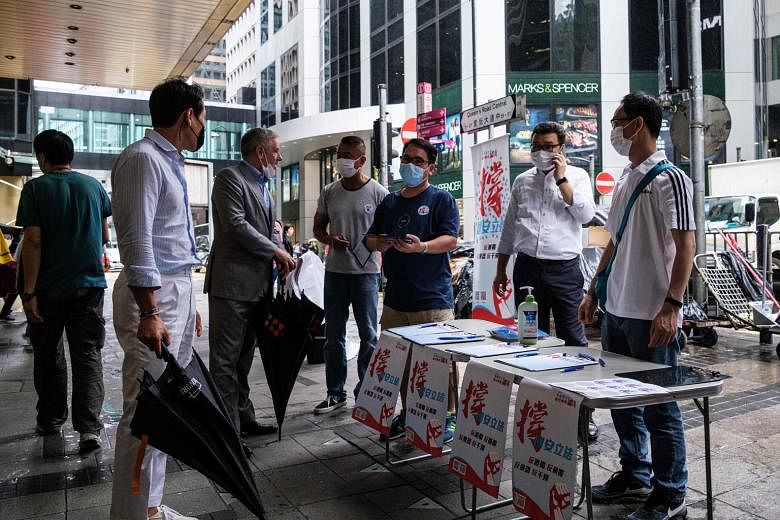 Some passers-by speaking to people at a booth where the public can give their signatures in support of a new security law in Hong Kong yesterday.