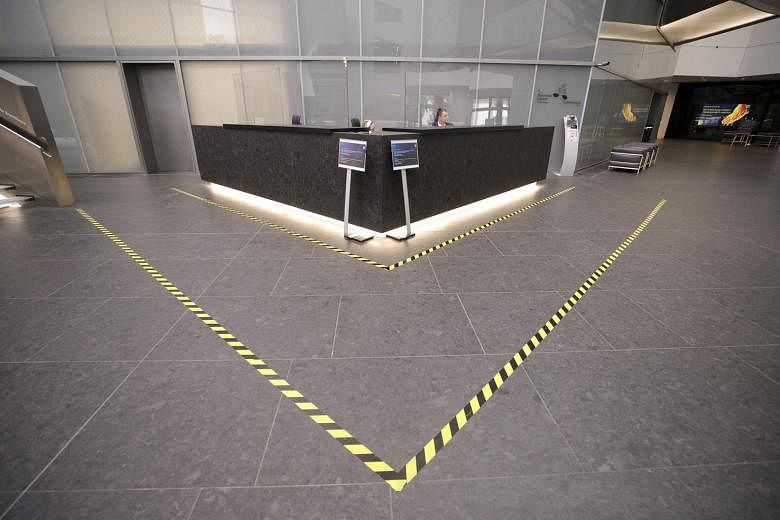 Tables and seats at a dining area cordoned off with tape in the staff canteen and social distancing floor markers at the reception desk in the lobby at Deutsche Bank's headquarters in Frankfurt earlier this week.