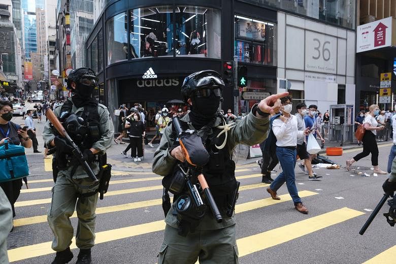 Riot police armed with pepper ball rifles in the Central district during a protest in Hong Kong on Wednesday. Officers fired pepper spray projectiles as protesters hit the streets to oppose China's increasing control over the city - a return to the s