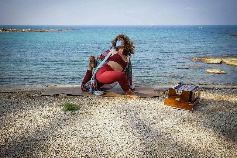 Lebanese yoga instructor Jihane Nasrallah practising at the seafront while wearing a mask during the coronavirus pandemic.