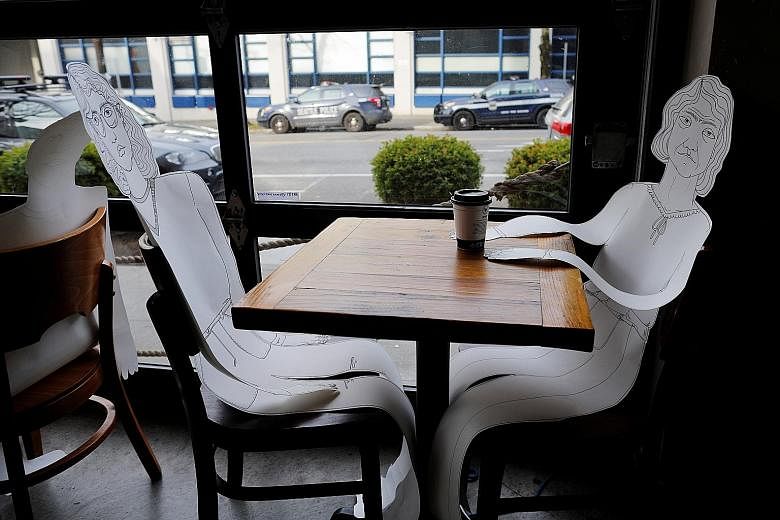 Only take-out service is allowed at bagel cafe Eltana (above) in Seattle in the United States, but paper cutouts of customers ensure its tables stay filled. 