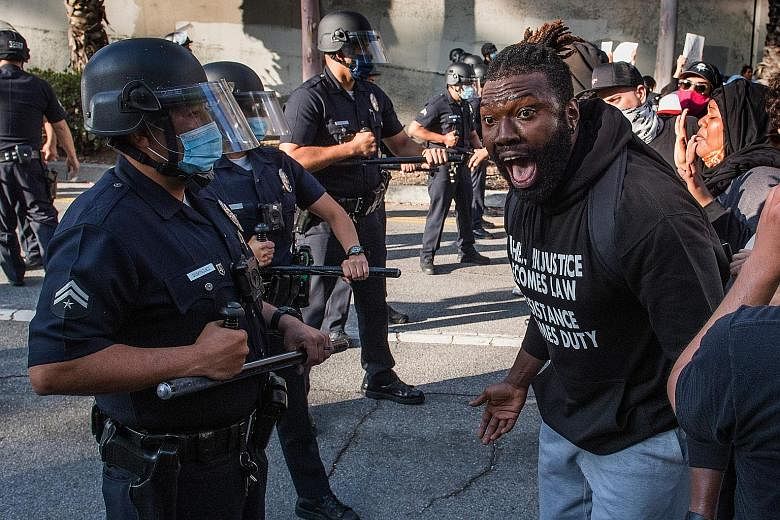 Mr George Floyd died last Monday after a white police officer pinned him down by the neck for several minutes. LOS ANGELES A demonstrator confronting police officers on Friday, amid a rising tide of anger in the US over the treatment of minorities by
