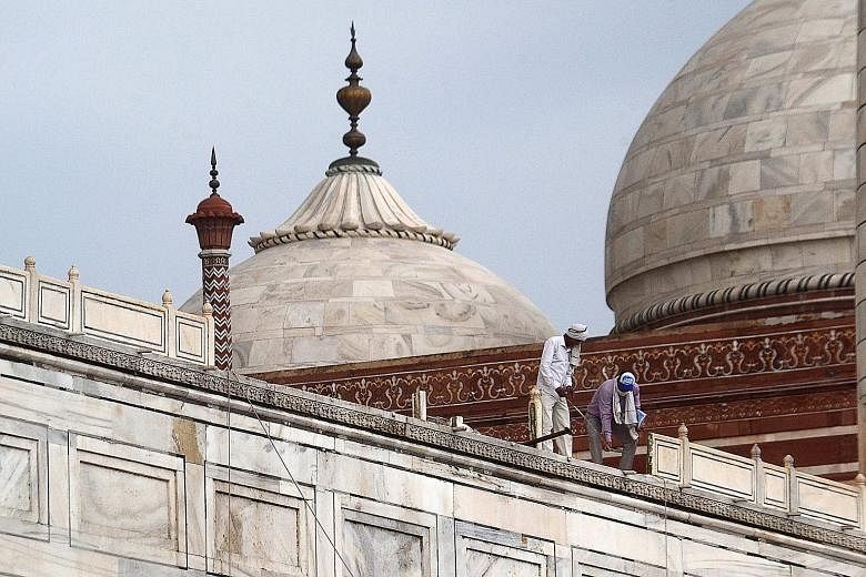 Workers assessing the damage at the Taj Mahal after parts of the complex were damaged in a heavy storm last Friday night. PHOTO: AGENCE FRANCE-PRESSE