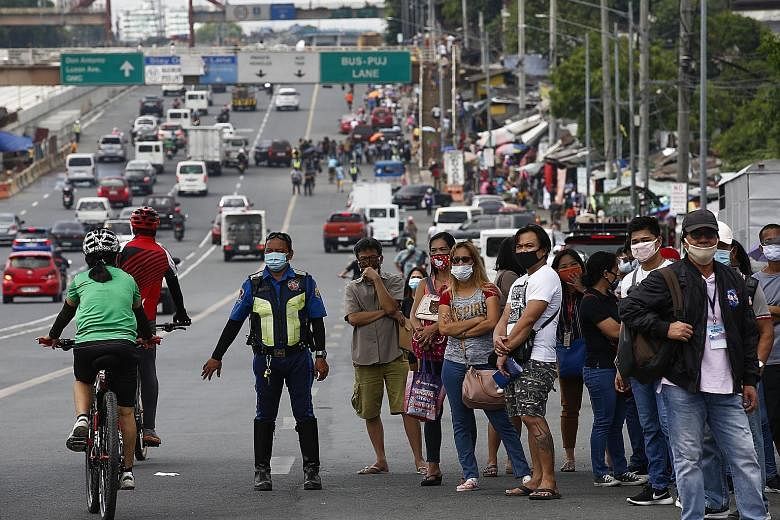 People waiting for transport in Quezon City yesterday. The army had to deploy at least eight lorries to ferry those who were stranded on the roads.