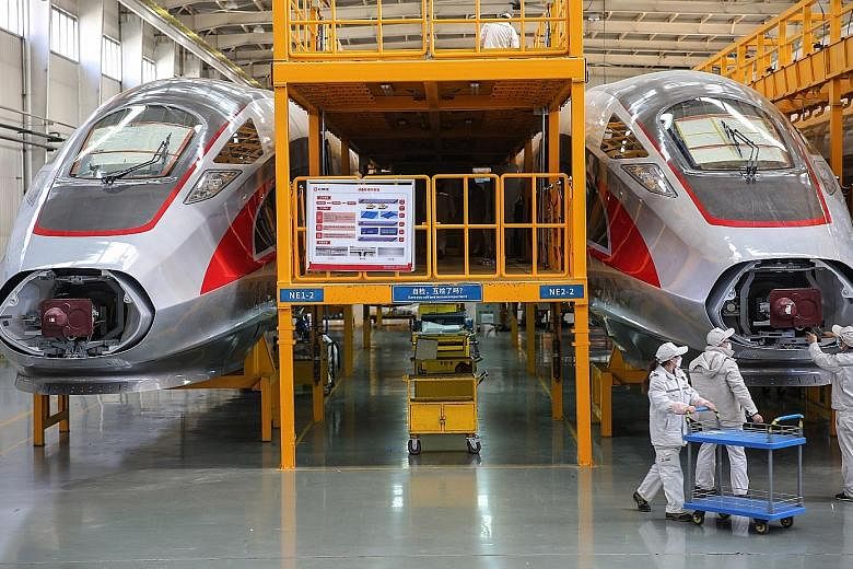 Workers checking on newly made bullet trains at a factory in Qingdao in China's eastern Shandong province in March. China's factory activity unexpectedly returned to growth last month, but with many trading partners still restricted due to the corona