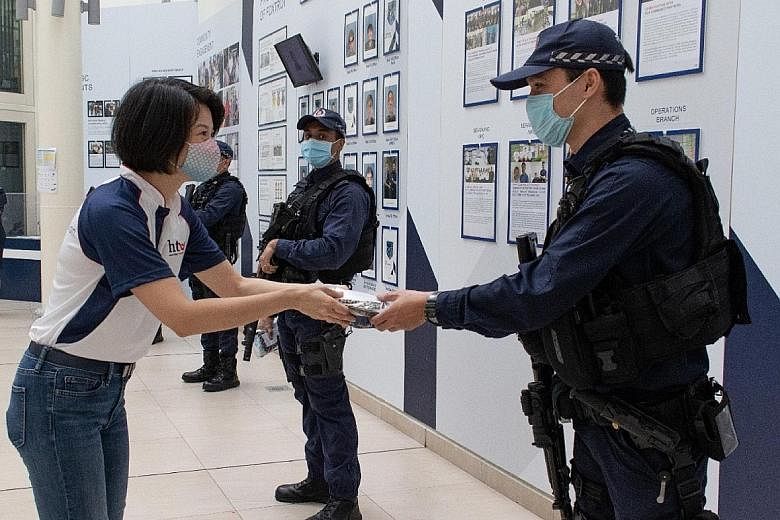 Senior Parliamentary Secretary for Home Affairs Sun Xueling presenting the care pack to an officer from the Ang Mo Kio Police Division last Thursday.