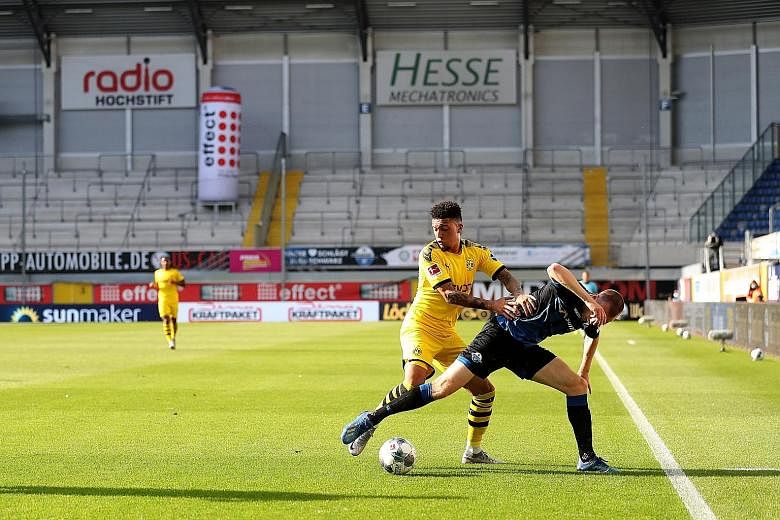 Jadon Sancho (left) fighting for the ball with Sebastian Schonlau of Paderborn in Dortmund's 6-1 win. The 20-year-old Englishman, who was let go by Manchester City, netted his first hat-trick for the Bundesliga side. PHOTO: EPA-EFE
