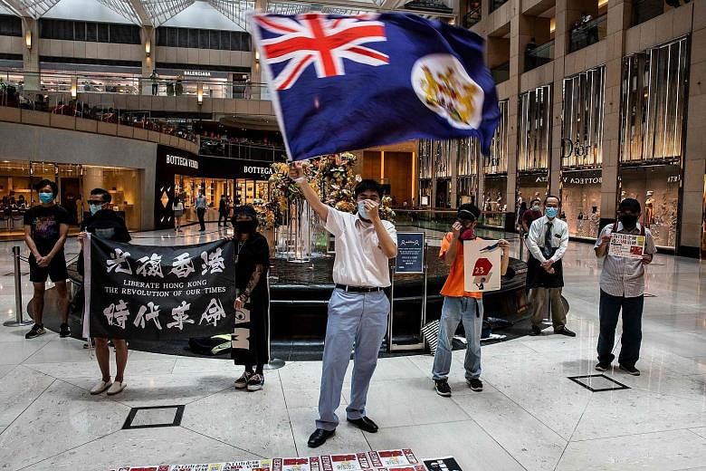 A pro-democracy protester waving a British colonial flag during a lunchtime rally at a shopping mall in the Central district of Hong Kong on Monday. Chief executive Carrie Lam is facing renewed protests as China's plan to enact the national security 