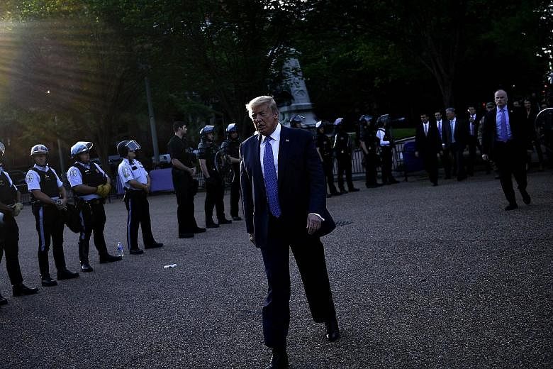 Above: People running for cover as riot police fired tear gas to clear the area around the White House on Monday night. PHOTO: REUTERS Left: President Trump walking back to the White House after his photo opportunity outside St John's Episcopal Churc