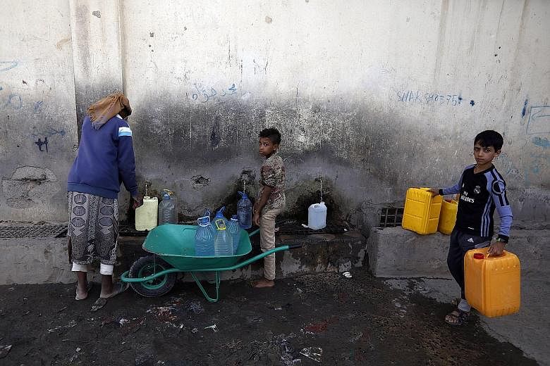 Yemenis collecting clean water from a charity tap on Monday. A long conflict between a Saudi-led coalition and the Iran-aligned Houthi group has left 80 per cent of Yemen's population reliant on aid.