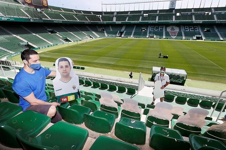 Stadium staff placing cardboard cut-outs with pictures of Elche fans on the stands of the second-tier club's stadium. Elche are preparing for the resumption of matches behind closed doors due to the ongoing coronavirus pandemic.