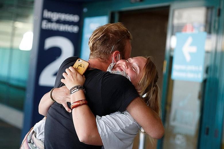A couple hugging upon the woman's arrival from Germany at Rome's Fiumicino International Airport yesterday. Arrivals in Italy from Europe will not be required to self-isolate unless they have travelled from another continent.