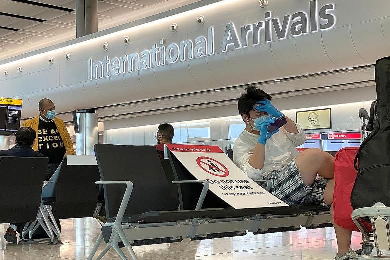 Travellers at London's Heathrow Airport. From Monday, international arrivals to Britain will have to self-isolate for 14 days.
