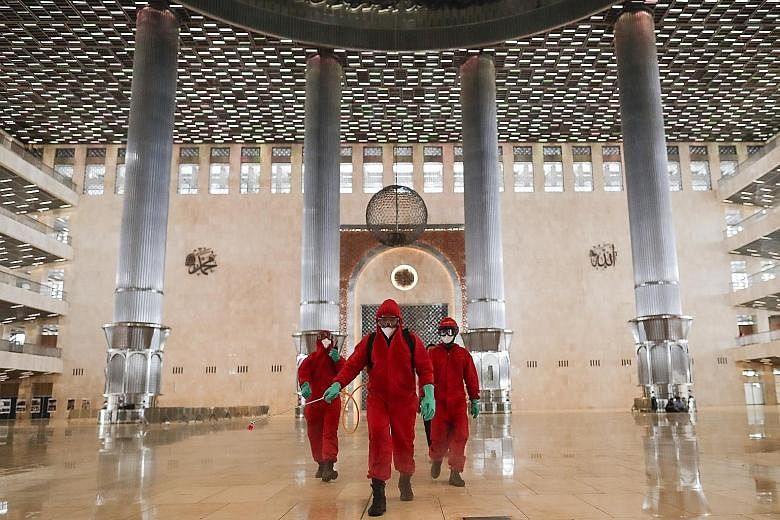Disinfectant being sprayed at Istiqlal Mosque in Jakarta on Wednesday. Places of worship in the Indonesian capital can open their doors from today, as part of a transition phase over the next few weeks. The city administration can reinstate restricti