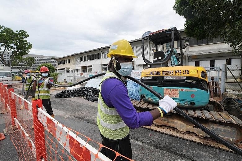 Workers from SP Group doing cabling work on May 13 to prepare a building in Genting Lane to house quarantined Covid-19 patients.