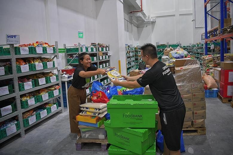 Ms Audrey Wong and Mr Jameson Chow of The Food Bank Singapore sorting out donated food last December. The new virtual food banking app will allow donors to share the type and quantity of food they have in real time, which food support organisations c
