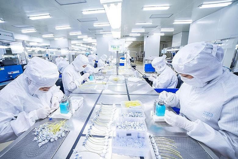 Employees assembling medical devices in a clean room in Forefront Medical's facility in Singapore. Among the five projects related to the coronavirus it has secured recently are test kit and nasal swab production.