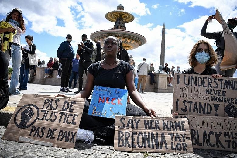 Protesters with placards reading "no justice no peace" and other messages at the Place de la Concorde, near the US embassy, in Paris yesterday, as part of global rallies against racism and police brutality. PHOTO: AGENCE FRANCE-PRESSE