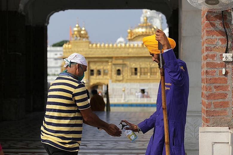 A devotee getting his hands sanitised before entering the Golden Temple in Amritsar, the holiest of Sikh places, after places of worship in India were allowed to reopen yesterday, with special guidelines during the ongoing lockdown due the coronaviru
