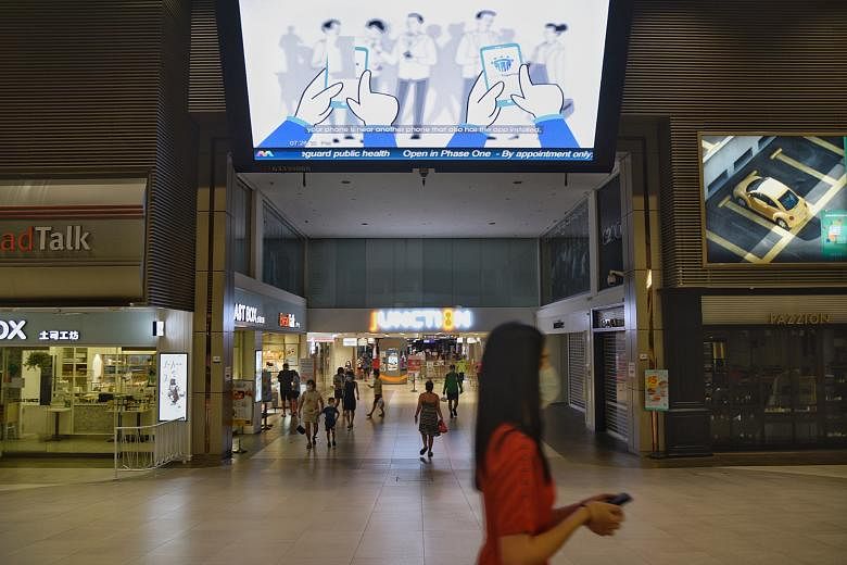 An advisory for the TraceTogether app being shown on a giant screen at Junction 8 mall on Sunday. ST PHOTO: DESMOND WEE
