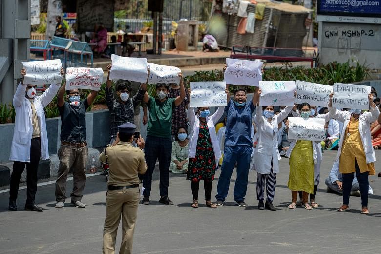 Relatives carrying the coffin of a man who died of Covid-19 at a burial ground in New Delhi on Monday. PHOTO: REUTERS Doctors from Gandhi General Hospital in Hyderabad protesting yesterday after an alleged attack on medical staff by relatives of a de