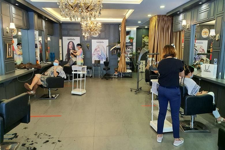 Social distancing measures in place at a hair salon in Kampung Pandan, Kuala Lumpur, yesterday, the first day of Malaysia's recovery movement control order phase that is scheduled to last until the end of August. During this phase, restrictions will 
