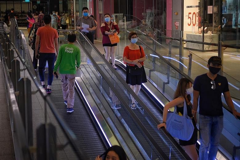 Above: People at Jem mall in Jurong yesterday. The Government is carefully monitoring the effects of increased activity in phase one of the reopening, and if the community infection rates remain low and stable, phase two could happen before the end o