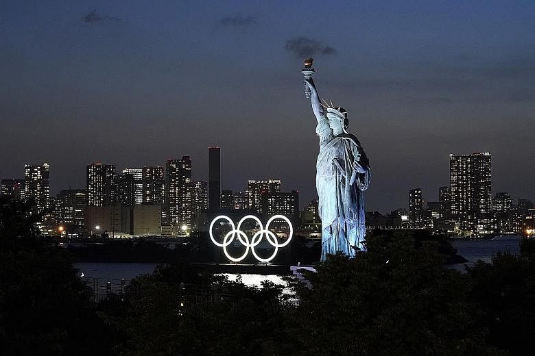 A replica of the Statue of Liberty near illuminated Olympic rings floating in the waters off Odaiba island in Tokyo. About two-thirds of the Games sponsors are unsure if they can maintain their backing in view of the one-year delay.