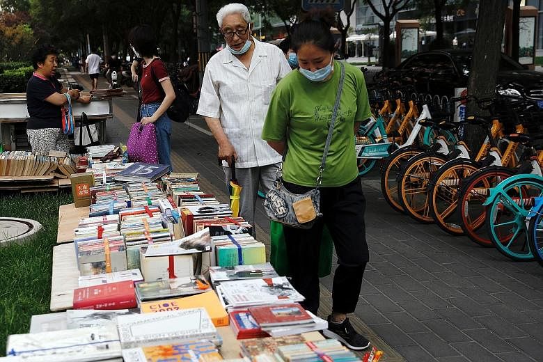 Customers browsing at a street stall at the Sanlitun shopping area in Beijing last week. Official broadcaster CCTV said roadside stalls were not "appropriate for first-tier cities", like Beijing, Shanghai, Guangzhou and Shenzhen. PHOTO: REUTERS