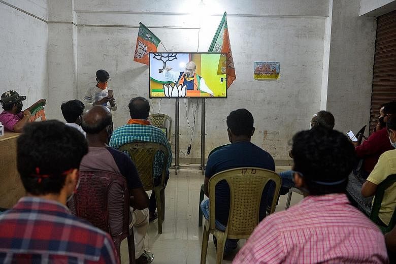 Supporters of the Bharatiya Janata Party watching Home Minister Amit Shah speak at an online rally in the city of Siliguri in India's north-eastern West Bengal state on Tuesday. The politician has held at least three rallies this week as part of a di