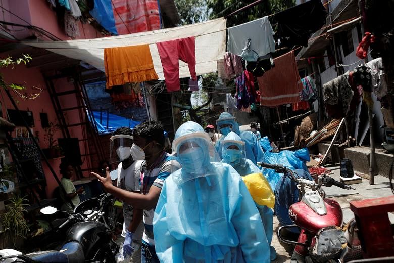 Healthcare workers and volunteers visiting the Dharavi slum in Mumbai earlier this month. The authorities have knocked on 47,500 doors since April to measure temperatures and oxygen levels, and have screened almost 700,000 people, in an aggressive ef