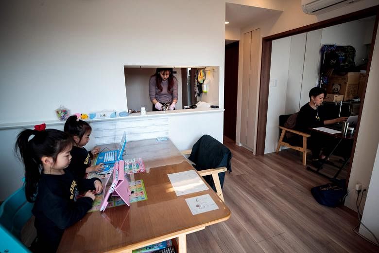 Mr Yuki Sato, an employee in a start-up company, working from home in Tokyo while his wife Hitomi washes the dishes and his daughters do their homework. In Japan, many electronics firms have kept in place telework arrangements as the "new normal", af