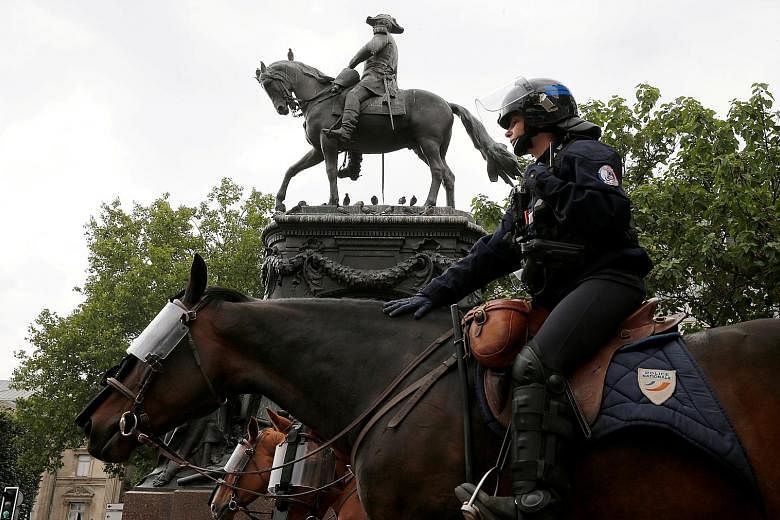 A French police officer guarding a statue of Louis Faidherbe, a French general and colonial administrator in the 19th century, in Lille before a protest against alleged police brutality last week. PHOTO: REUTERS