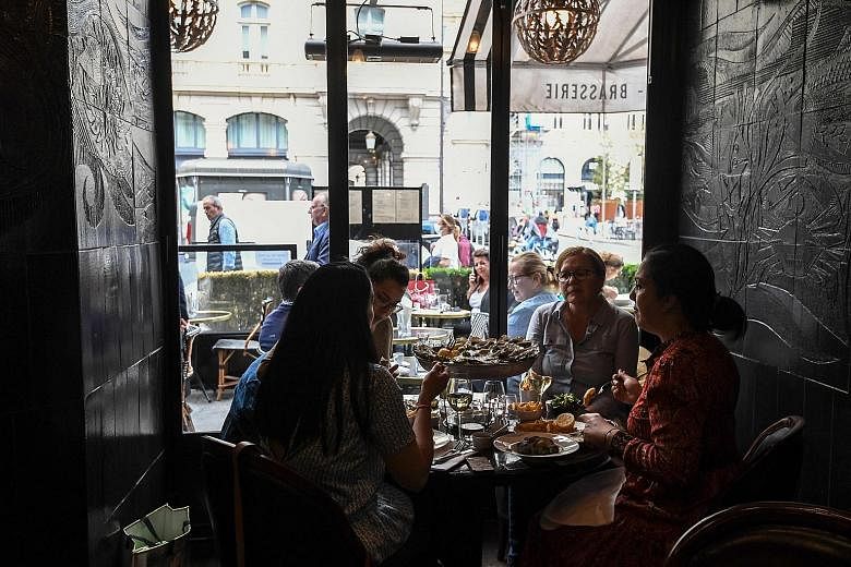 Customers at a restaurant in Paris yesterday. Before the sooner-than-expected reopening announced on Sunday, eateries in and around the French capital could only serve clients on outdoor terraces.
