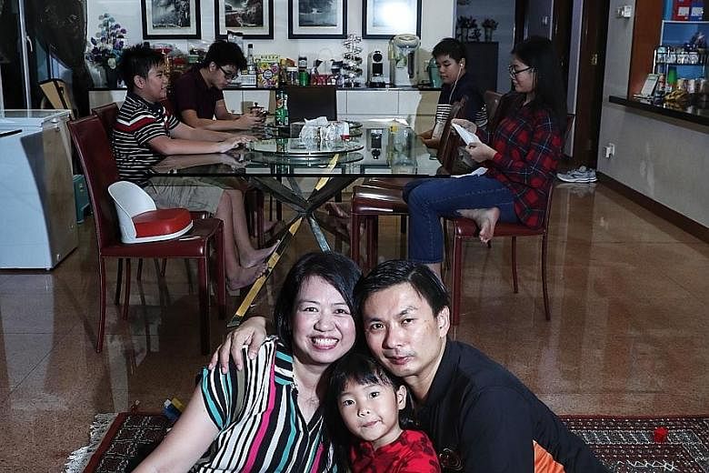 Madam Tay Hwee Ling and her husband Kelvin Lim adopted Mikaela (centre), five, whom they have taken care of since her birth. Seated behind them are the Lim's biological children, who are aged between 12 and 16. There have been a few foster parents li