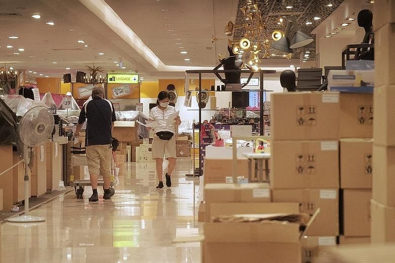 Workers sorting out goods at Metro Paragon (above) and staff preparing items for sale inside a Skechers outlet (right) at Nex mall yesterday. Stores that reopen on Friday must follow strict safety measures, including frequent cleaning and implementat