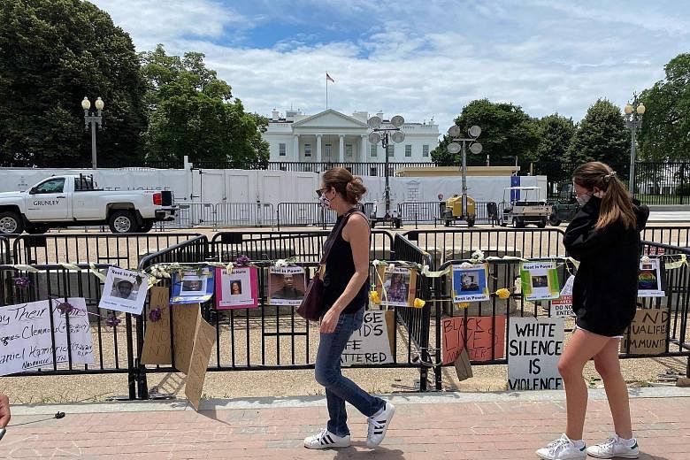 Photo posters and signs, put up by demonstrators protesting against police brutality, hanging from barricades across from the White House in Washington on Monday. American lawmakers are working on legislative responses to the calls for police reform.
