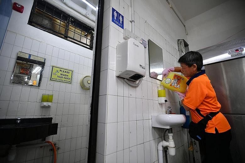 An employee refilling liquid hand soap in a coffee shop in Yishun earlier this year. Public toilet owners and operators must ensure the facilities have basic amenities such as liquid hand soap, toilet paper and litter bins. ST PHOTO: LIM YAOHUI