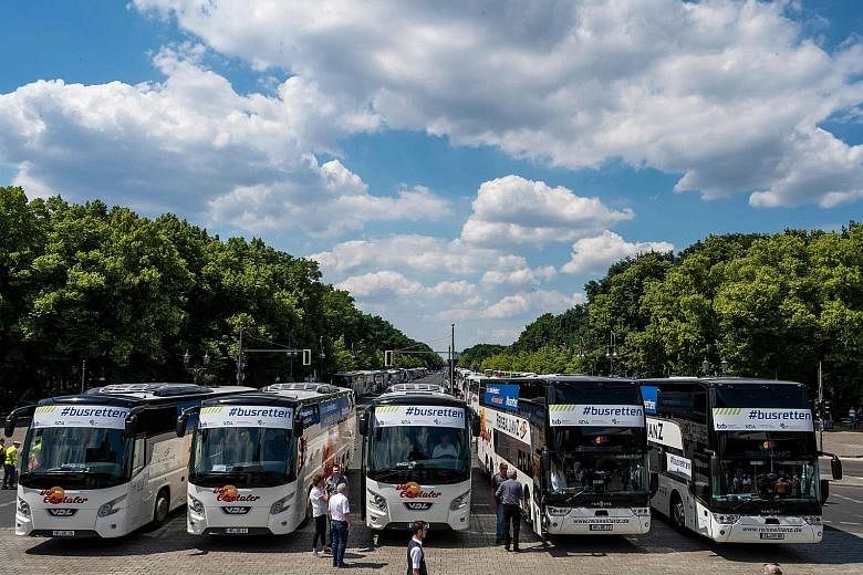 Buses parked in front of the Brandenburg Gate yesterday, during a protest by operators of travel coach companies in Berlin, Germany. They rallied along the 17 Juni Boulevard, asking for more financial help amid the coronavirus pandemic that has cripp